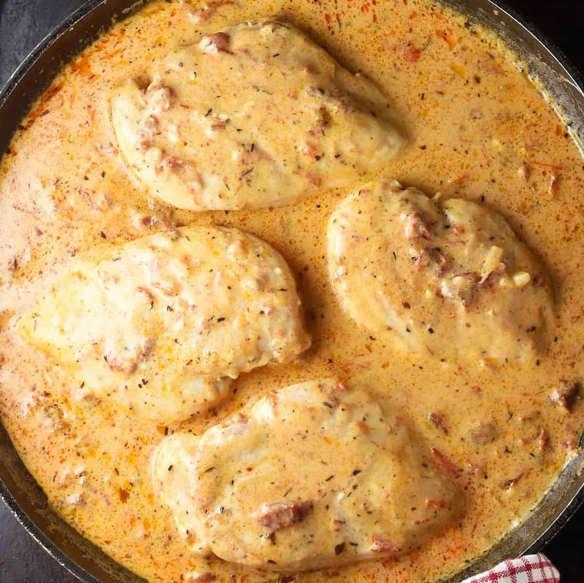 Top down view of creamy healthy marry me chicken breasts in skillet.