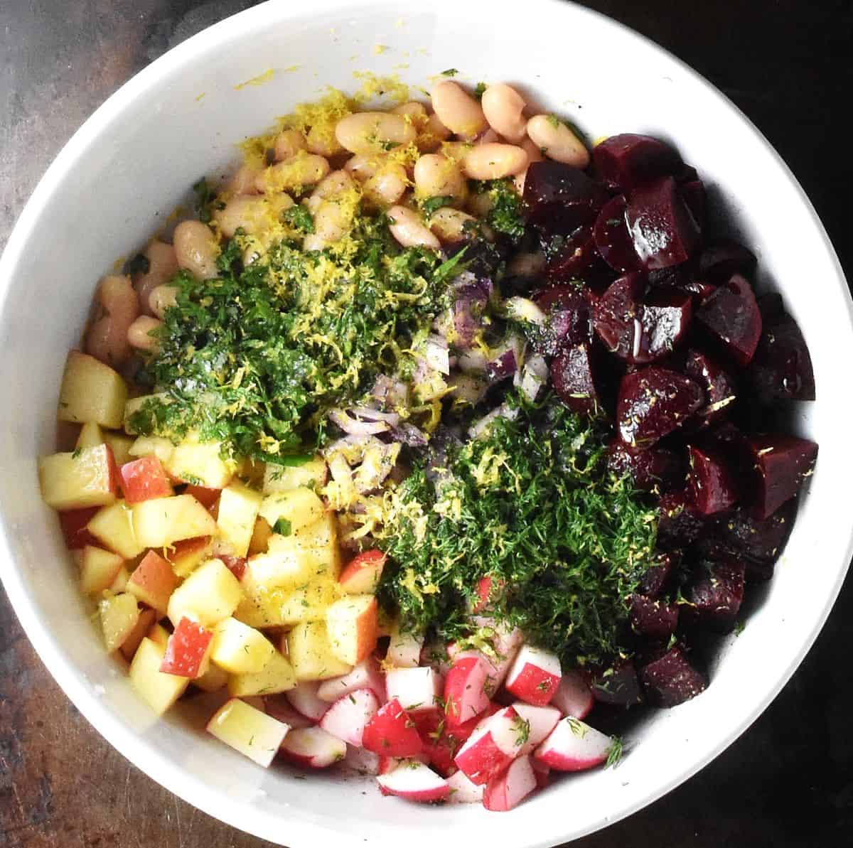 Pickled beet salad ingredients assembled in white mixing bowl.